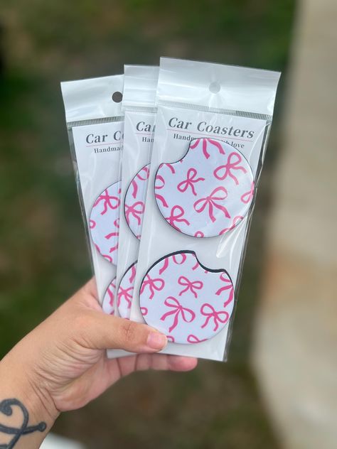 trendy coqute bow car coasters. The perfect addition to your car!  They come in a pack of 2 and they neoprene material.  The design is sublimated onto the coaster, for longer lasting. Cute Pink Car Decor, Aesthetic Car Stuff, New Car Essentials, Car Necessities For Women, White Car With Pink Accents, White Car Pink Accents, Car Decorations Interior Girly, Cute Car Interior Ideas, Car Decorations Interior Aesthetic