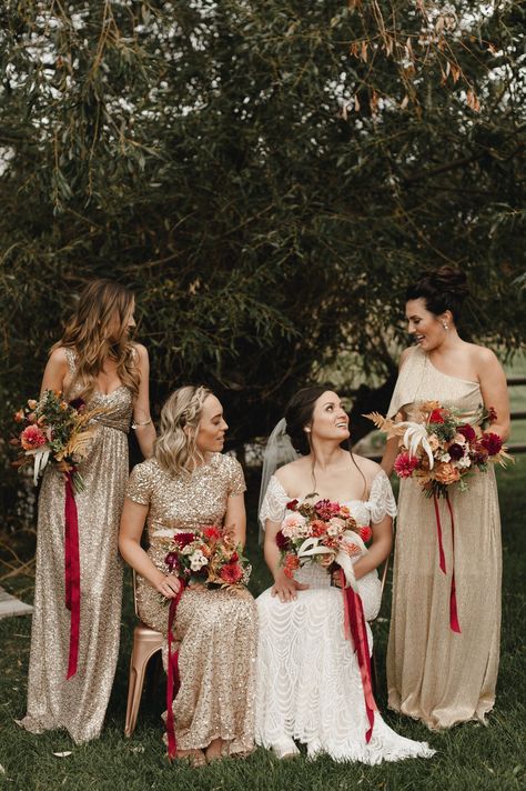 Sparkling gold bridesmaid dresses and red ribbon wrapped wedding bouquets are the perfect matching look for an elegant fall wedding. The gold dresses with the bride's off-the-shoulder embellished wedding dress also gives us major Great Gatsby vibes for a vintage 1920s-inspired wedding. Here are other bridesmaid dress ideas for a fall wedding. // Photo: Carina Skrobecki Mountain Honeymoon, Wedding Party Attire, Bridesmaid Dress Ideas, Montana Bride, Fall Bridesmaid, Gold Wedding Gowns, Groomsmen Looks, Fall Bridesmaids, Fall Bridesmaid Dresses