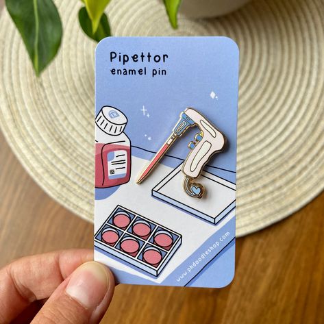 Add a touch of science to your wardrobe with this cute and stylish pipetter enamel pin. Perfect for scientists, nurses, or anyone who loves science! #science #enamelpin #nurse . #Enamel_Pins_Diy #Science_Pins #Laboratory_Scientist #Cell_Culture Enamel Pins Diy, Science Pins, Laboratory Scientist, Medical Pins, Cell Culture, Graduate Student, Pin Cute, Pipettes, Petri Dish