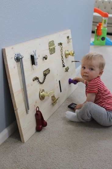 Other people added a rod with things to slide, a mirror, keys, and the child's name (the letters may also slide) - anything interactive!  Definitely screw this into the wall and maybe even seal it to avoid splinters. Baby Activity Board, Diy Busy Board, Toddler Activity Board, Busy Board Baby, Sensory Board, Baby Play Activities, Busy Boards For Toddlers, Sensory Boards, Diy Toddler