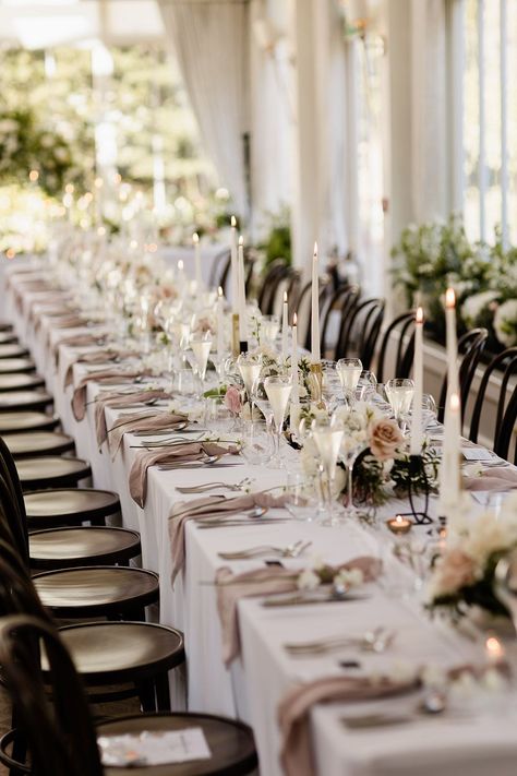 Small floral arrangements line banquet table covered with white tablecloth and fabric pink napkins White Tablecloth Tablescape, White Tablecloth Beige Napkins Wedding, Pink Table Linens Wedding, Wedding Rectangular Table Decorations, Taupe Tablecloth Wedding, Cream Table Cloth Wedding, Round Table Runner Wedding, Ivory Tablecloth Wedding, Champagne Tablecloth Wedding