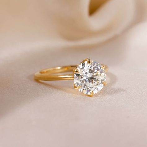 This yellow gold solitaire engagement ring elevates and enhances the round brilliant cut diamond in a way in which this simple claw prong solitaire features an open basket with six elegant leaves that cradle the center diamond. Handcrafted in Hatton Gardens, London. Round Engagement Ring Gold, Solitaire Engagement Rings, 1 Carat Engagement Rings, Yellow Gold Solitaire Engagement Ring, Unique Diamond Wedding Rings, Gold Band Engagement Rings, Small Engagement Rings, Stunning Diamond Rings, Gold Solitaire Engagement Ring