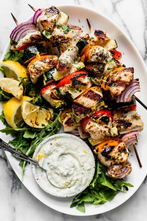 Photo of Greek Chicken Kebabs with Tzatziki Sauce on a serve platter with arugula, grilled lemons and a bowl to Tzatziki sauce. Authentic Greek Food, Greek Chicken Kebabs, Greek Chicken Kabobs, Weekend Meal Prep, Tzatziki Sauce Recipe, Dorito Casserole, Real Food Dietitians, Greek Foods, Greek Flavors