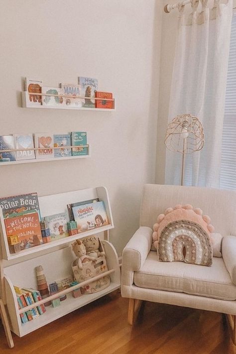 Bookshelf Under Window Nursery, Small Nursery Book Storage, Book Storage Ideas Nursery, Nursery Book Display, Book Shelf Nursery Ideas, Nursery Book Nook, Nursing Nook Ideas, Book Storage In Nursery, Nursery Bookcase Ideas