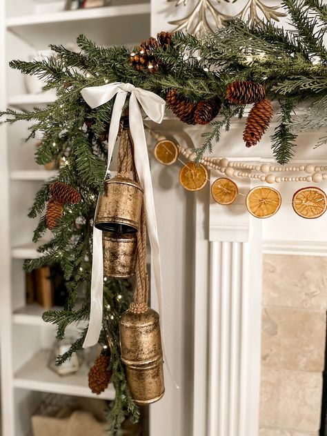 Fireplace Garland And Bells, Styling A Christmas Mantle, Gold Bells On Mantle, Christmas Decor Ideas For Window Display, Scandi Christmas Garland, Christmas Fireplace Garland Farmhouse, Christmas Gold Bells, Taxidermy Christmas Decor, Gold Christmas Bells Decorations