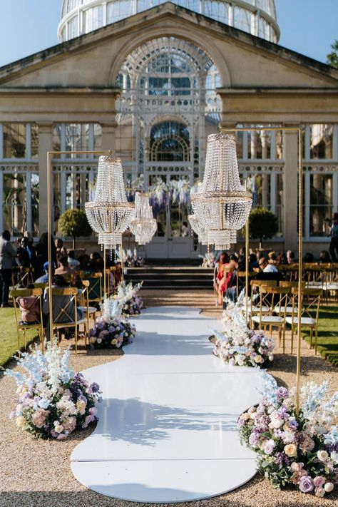 Syon Park wedding venue with outdoor gold and crystal chandeliers and pastel aisle flower arrangements outside of The Great Conservatory for vow renewal Chandelier Wedding Aisle, Wedding Ceremony Luxury, Chandelier Wedding Backdrop, Syon Park Wedding Conservatory, Wedding Backdrop With Chandelier, Chandelier Outdoor Wedding, Outdoor Chandelier Wedding, Wedding Chandelier Ideas, Wedding Dress Pastel