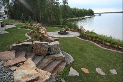 Hill Side Landscaping Sloped Yard Rocks, Lakehouse Backyard Landscaping, Lake Retaining Wall, Landscape On A Slope, Lakehouse Backyard, Lakefront Landscaping, Lake House Backyard, Natural Stone Steps, Tiered Landscape