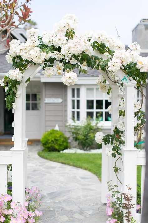 A winding stone pathway flanked by a white picket fence leads through a flower covered front gate arbor. Garden Gate Design, Home Bunch, Front Fence, Garden Arbor, Front Yard Fence, White Picket Fence, Front Yard Garden, Backyard Fences, Fence Gate