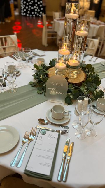 G&L Elegant Occasions on Instagram: "Another lovely night at @bartonhallhotelandspa wedding fair ✨ Sage green and cylinder vases with floating candles is always one table everybody loves! 😍 • • • • • #wedding #weddingday #engaged #engagement #weddingdecor #weddingsnorthamptonshire #weddingseastmidlands #weddingsleicestershire #eventdecor #bridetobe #groomtobe #weddingstyle #venuestyling #venuestylist #wedding2024 #bride2024 #bride2025 #weddingday #venuestyling #venuestylistnorthamptonshire #bartonhall #bartonhallwedding #sagegreen #sagegreenwedding" Green And Beige Wedding Table Decor, Sage Green Wedding Reception Table, Sage Green White And Gold Centerpieces, Plant Table Setting, Olive Green Wedding Theme Table Settings, Sage Green And Silver Wedding Table Settings, Sage Green Wedding Sweetheart Table, Sage Green And White Wedding Table Settings, Sage Green And Gold Wedding Theme Centerpieces