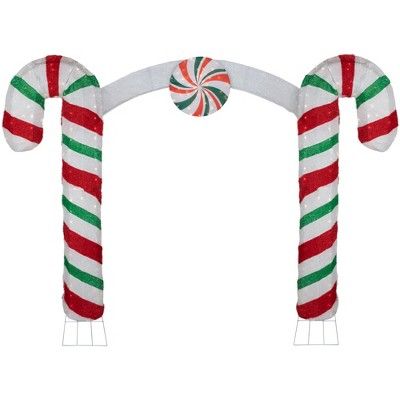 Create a one of a kind holiday wonderland with this huge double candy cane archway. Pre-lit with 350 warm white lights, this showstopper will add tons of that holiday glow. Classic candy cane stripes and added red bow, lend a familiar yet striking appearance. Iridescent fabric add shimmer. Place anywhere outdoors and watch as your home takes center stage!  Product Features: Lighted outdoor candy cane archway decoration Pre-lit with 350 clear lights Bulb size: mini Bulb type: incandescent 60" whi Archway Outdoor, Iridescent Fabric, Warm White Lights, Classic Candy, Christmas Yard Decorations, Christmas Parade, Candy Cane Stripes, Christmas Central, Christmas Yard