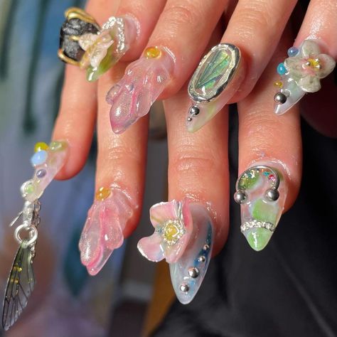 An up close photo of hands with almond shaped nails with colourful 3D design featuring a sculpted bee, pink flowers, a U-shaped piercing and a dangling translucent insect wing on a metal hoop. Most prominent colours are baby pink, pastel green, sky blue and iridescent silver. Pastel Nails With Flowers, 2d Nail Art, Nails With Flowers, Cute Nail Polish, January Nails, Nail Designs Tutorial, Really Cute Nails, Crazy Nails, Nails Only