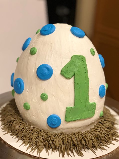 Dinosaur egg cake 1st birthday buttercream egg shaped cake. This egg shape was my first ever hand carved cake! 😁 Dinosaur Egg Cake, Egg Shaped Cake, Cake 1st Birthday, Dinosaur Birthday Theme, Dinosaur Birthday Party Decorations, Dinosaur Birthday Cakes, Boys First Birthday Party Ideas, Dinosaur Egg, Dinosaur Themed Birthday Party