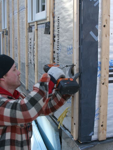 Photo of a builder installing furring strips over polyiso wall sheathing Foam Board Insulation, Rigid Foam Insulation, Foam Insulation Board, Exterior Insulation, Rigid Insulation, Roof Sheathing, Fiber Cement Siding, Garage Kitchen, Installing Siding