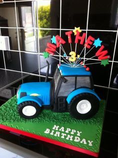 Shaped blue tractor cake, made for a little boys third birthday. Tractor wheels made out of Rice Krispies and marshmallows and covered in black fondant. Kids Construction Cake, Tractor Party Decorations, Tractor Birthday Cakes, Cow Birthday Cake, Tractor Wheels, Baby Shower Fruit, Tractor Cake, Tractor Birthday Party, Tractor Party