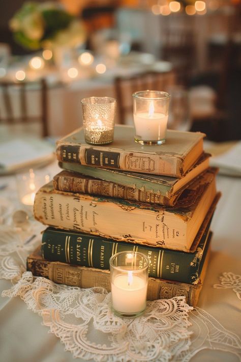 Transform your wedding tables into a storybook scene with our antique book centerpieces! 📚💒 Delicate lace runners and warm votive candles complete the romantic ambiance. Perfect for bibliophiles saying I do! #WeddingInspiration #VintageWedding #BookLover #RomanticDecor #WeddingIdeas #Candlelight #AntiqueChic #LaceDetails Let the love stories of old add charm to your special day! Book Themed Table Centerpieces, Book Wedding Favors, Book Lover Wedding Ideas, Nonfloral Centerpiece Ideas, Book Centerpiece Wedding, Storybook Wedding Theme, Bookish Wedding Ideas, Book Centerpiece Ideas, Books Table Decor