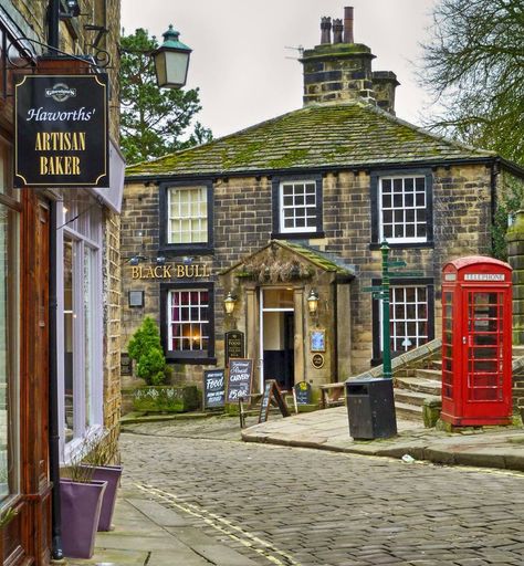 The Black Bull pub in Haworth village, West Yorkshire. Known for its association with the Brontë sisters, the village name is thought to mean "hedged enclosure". Red Telephone, British Pub, Oxford England, English Village, Black Bull, Yorkshire England, England And Scotland, To Infinity And Beyond, English Cottage