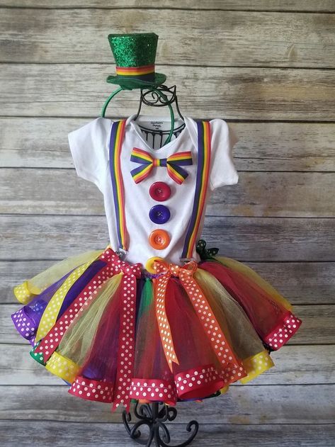 This listing is for the most adorable girls Clown Costume. This Stunning 3 set is complete with a 6 colored rainbow tutu made of high quality tulle with ribbon sewn to the end, a bodysuit or shirt with ribbon suspenders, 4 matching buttons sewn on the shirt, matching bows and hair bow. PLEASE SEE OUR LISTING FOR A MATCHING TUTU TRICK OR TREAT BAG! https://www.etsy.com/listing/629270220/clown-candy-bag-circus-candy-bag?ref=shop_home_active_24 Girl Clown Costume, Carnaval Make-up, Rainbow Costume, Costume Rainbow, Costume Clown, Rainbow Costumes, Unicorn Birthday Outfit, First Birthday Tutu, Candy Costumes