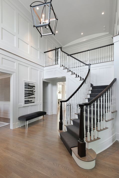 Two story foyer features Restoration Warehouse Hollis Pendant illuminating board and batten walls framing black and white abstract art over lucite bench with black velvet cushion across from a sweeping staircase lined with gray stair runner. Foyer Lighting Fixtures, Two Story Foyer, Dark Floors, Modern Entryway, Foyer Lighting, Foyer Decorating, Entrance Foyer, Foyer Design, Board And Batten