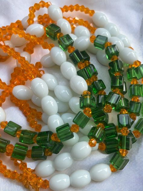 Double Strand Elastic Waist Bead "Daoukro" – a vibrant creation meticulously crafted with lively orange glass crystal seed beads, elegantly adorned with accents of pure white and refreshing green crystal glass seed beads. This double-strand elastic waist bead not only embodies the zest of citrus blooms but also radiates a harmonious charm, offering a comfortable and adjustable fit that transcends beauty and symbolism. 🍊 Orange Glass Crystal Seed Beads - Citrus Zest: Daoukro is adorned with a burst of lively orange glass crystal seed beads, capturing the essence of citrus zest. The vibrant hue symbolizes energy and enthusiasm, adding a touch of lively brilliance to your ensemble. 🌼 White and Green Crystal Glass Seed Bead Accents - Fresh Elegance: Intertwined among the orange beads are del Orange Glass Beaded Necklace With Colorful Beads, Orange Glass Beaded Jewelry, White Glass Beaded Necklaces For Gifts, White Beaded Necklaces With Oval Beads, White Glass Beaded Bracelets For Jewelry Making, White Glass Beaded Bracelets With Round Beads, White Bohemian Beaded Necklace With Faceted Beads, White Glass Beaded Bracelets, Handmade White Glass Beaded Necklaces