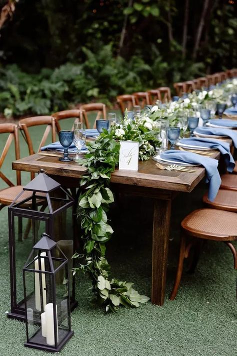 Wood Farm Table With Blue Napkins and Greenery Garland Farmhouse Table Eucalyptus Wedding, Blue Boho Party Decor, Long Table Wedding Centerpieces, Farm Table Setting, Venue Aesthetic, Wood Farm Table, Farm Table Wedding, Wedding Table Deco, Navy Table Runner