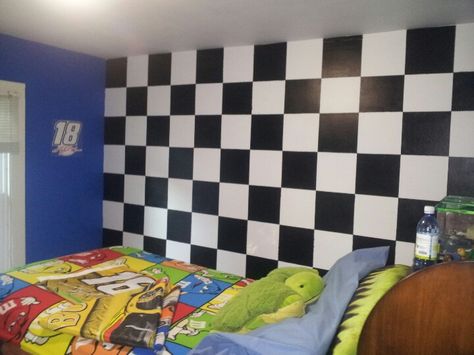 NASCAR themed bedroom with checkered flag wall Checkered Wall Bedroom, Nascar Room Ideas, Checkered Bedroom, Modern Race Car Bedroom, Nascar Bedroom Ideas, Racecar Bedroom Toddler, Nascar Themed Room, Checkered Wall, Checkered Wallpaper Boys Room