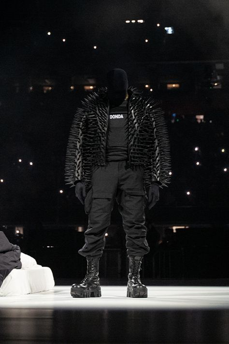 Kanye West in an all black outfit featuring a spike jacket from Balenciaga, vest with a ‘DONDA’ printed vest, cargos and boots. Minimal Swimwear, Kanye West Wallpaper, Kanye West Outfits, Chopped And Screwed, Balenciaga Black, All Black Outfit, Gaming Clothes, Hottest Trends, Black Outfit