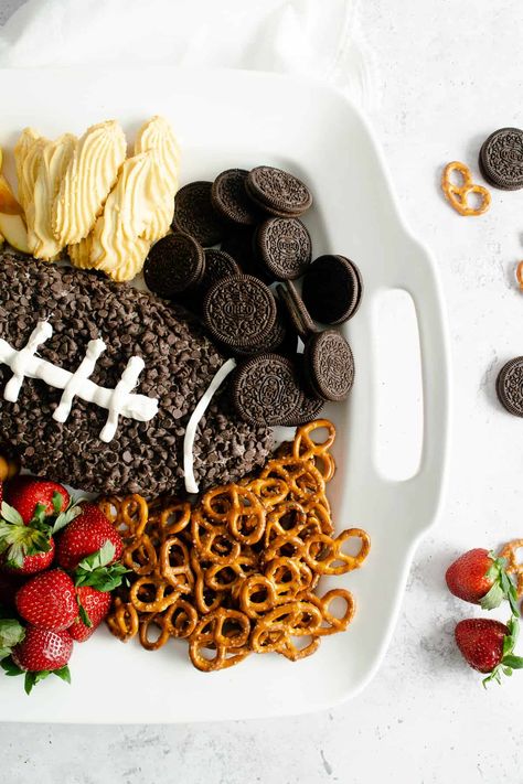 Score a touchdown with this easy and fun Football Cookies & Cream Cheesecake Dip for your next Game Day party and get ready to receive rave reviews! Whether you are there for the actual game or just for the half-time show and commercials, this simple dessert dip with Oreo cookies and mini chocolate chips can be made in 15 minutes and is sure to please! #dessert #dip #cheesecake #Oreo #cookiesandcream #gameday #football #chocolatechips #easy #snack #board Superbowl Party Dessert Ideas, Football Cheesecake, Super Bowl Charcuterie Board, Super Bowl Charcuterie, Superbowl Ideas, Football Desserts, Superbowl Desserts, Snack Boards, Cookies And Cream Cheesecake