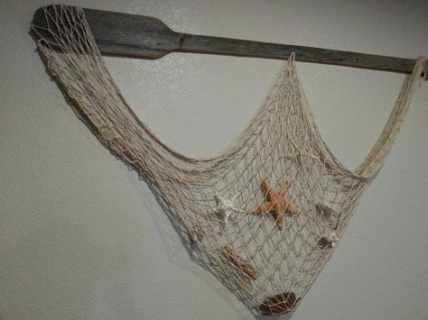 Barn wood oar with shells and netting for my beach themed basement. Decorating With Fishing Net, Fish Net Decor Ideas, Fishing Net Decor, Coastal Beach Bedroom, Fishing Net Wall Decor, Fish Net Decor, Brewery Ideas, Beach Theme Living Room, Boat Oars