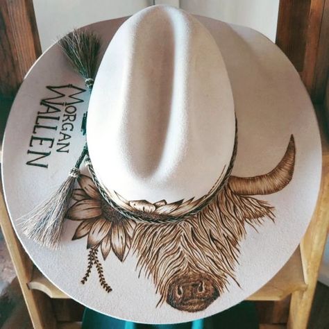 Bespoke Fedora Hat's & Hat Burning ✿ on Instagram: "I think I can hear a stampede...... The highland cow design is becoming a huge hit Here is the original highland cows baby sister off to rock out @morganwallen #customhats #burntdesigns #highlandcow #artist #pyrographyart #design #solspirits #cmcrocks #aussiebusiness #smalbiz #akubra #feltburning" Custom Burned Hat Ideas, How To Burn A Hat, Burned Hat Design Ideas, Felt Hat Burning Designs Diy, Stencils For Hat Burning, Burnt Hat Design, Felt Hat Burning Designs, Highland Cows Baby, Hat Burning Ideas