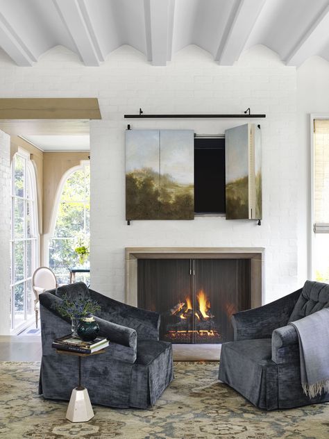 Hide TV behind a custom bifold painting and adorn with a long picture light. Tv Over Fireplace, Furnitur Ruang Keluarga, Hidden Tv, Indoor Fireplace, Modern Fireplace, Decoration Room, Winter Home Decor, Fireplace Wall, Living Room With Fireplace