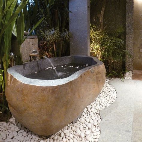 Huge river rock bathtub. Perfect to be placed outdoors, it is a natural bathtub that reminds of riverside stones with rounded edges. Sitting on a base made from small river stones, it is ideal for people who love being surrounded by nature. From the outside, it looks like a stone, but interiors with clean and sophisticated alcove tell the story of a modern bathtub. Made from rough beige granite, its outer surface nicely shows off intricate patterns of natural stone. Rock Bathtub, Bathroom Equipment, Balinese Garden, Cottage Interior Design, Marble Bathtub, Cream Marble, Modern Lake House, Modern Bathtub, Stone Bathtub