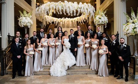 The bride and groom were joined by groomsmen in suits and orchid boutonnieres, as well as bridesmaids in sleek champagne-hued gowns featuring draped necklines. Large Bridal Party Ceremony, Huge Wedding Party, Large Bridesmaid Party, Wedding Photo Ideas Large Bridal Party, Large Bridal Party Photos, Large Bridal Party Pictures, Large Wedding Party Photos, Wedding Party Photos Group Shots, Classic Bridal Party