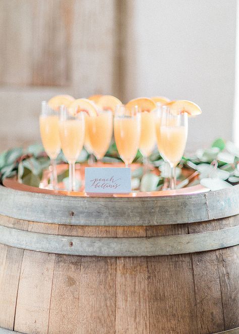 Peach Bellinis are displayed a top a wine barrel at a wedding at 48 Fields Farm in Leesburg VA Copper Chairs, Bellini Bar, Peach Bridal Showers, Wedding Brunch Reception, Signature Cocktails Wedding, Peach Party, Cha Bar, Peach Bellini, Copper Wedding