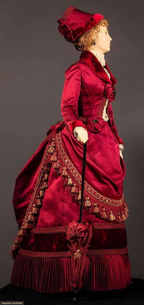 29" figure, period accurate 1885 visiting dress created & hand sewn by fashion designer John Burbidge: deep red silk satin & velvet bustle skirt & jacket, lace blouse, fringed & tasseled over skirt, includes matching parasol & hat, shoes, undergarments, all excellent. This is one of 75 "ladies" each costumed in a 1860 through 1914 unique ensemble, as seen in the book "Les Petites Dames de Mode" & numerous museum presentations throughout the U.S. Fashion Mannequin, 1880s Fashion, Bustle Skirt, Over Skirt, Bustle Dress, Victorian Costume, Fashion D, 19th Century Fashion, Victorian Clothing