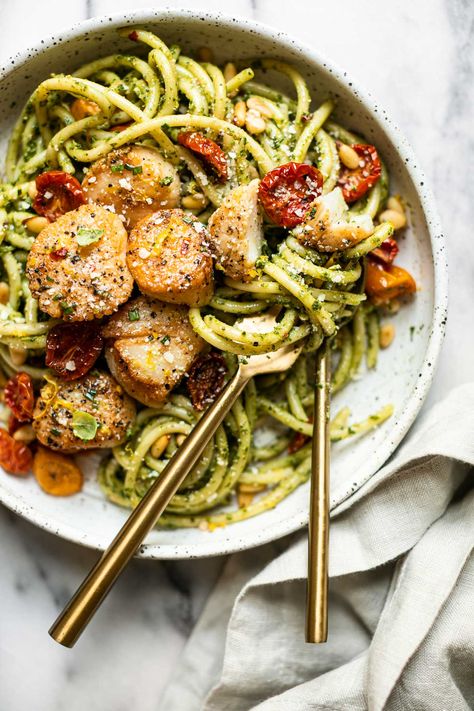 A bright & fresh scallop pasta dish – Seared Scallop Pesto Pasta! Al dente pasta tossed with herbaceous pesto & topped with perfectly seared sea scallops, roasted red peppers (or cherry tomatoes!), & toasted pine nuts. This seared scallops pasta recipe is the perfect warm weather dinner – great for for weeknight cooking, date night, girls' night, or any other spring & summer special occasions! #scalloprecipes #searedscallops #scalloppasta #pestopasta #pescatarianrecipes #pescatariandiet Scallop Pesto Pasta, Cooking Date Night, Scallops Pasta, Cooking Date, Scallop Recipes Pasta, Stove Recipes, Aldi Meals, Tilapia Recipes Easy, Seared Sea Scallops