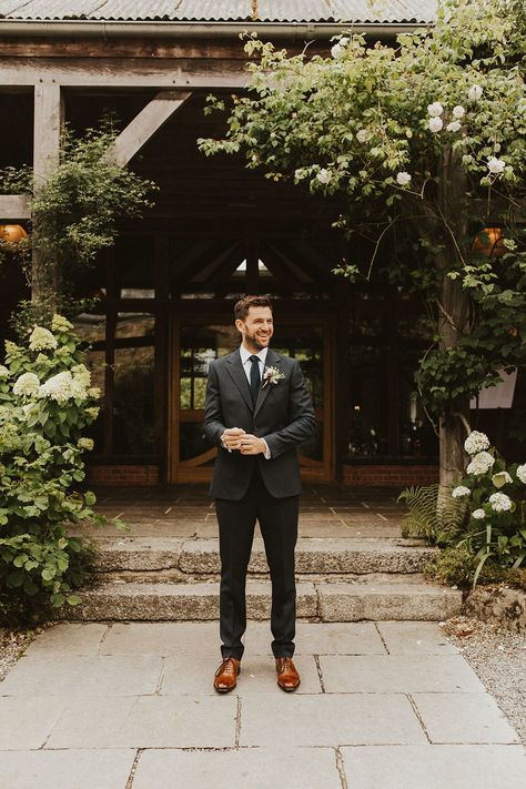 Groom in dark grey suit and brown leather shoes Groom Attire Dark Grey, Groom Suit Relaxed, Charcoal Suit Fall Wedding, Dark Charcoal Suit Wedding, Charcoal Suit With Brown Shoes, Dark Grey Wedding Suit Groom Attire, Groom Dark Grey Suit, Groom Suit Outdoor Wedding, Rustic Groom Suit