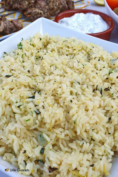 Rice in a bowl- Rice has herbs, onions and lemon mixed through it to make a delicious, fresh tasting dish for summer. In the background there is Tzatziki dip and pork souvlaki. Falafel And Rice, Recipes With Taziki Sauce, Taziki Rice Recipe, Jimmy The Greek Rice, Greek Style Rice, Greek Rice Salad, Greek Rice Recipe, September Meals, Greek Tzatziki Recipe