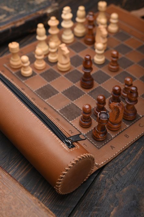 Leather Chess  Do you like to play chess and want to be able to do it even when you are on the go? A stylish leather roll for chess will give you such an opportunity. The set can be used at home, and at the same time it is compact enough to take with you on the road.    Advantages: * High-quality materials ensure a long service life. * Compact and lightweight, it is easy to store and light to transport. * Stylish design and excellent quality.    Product details: - 100% Handmade - Materials: genu Leather Chess Set, Leather Chess Board, Cool Chess Boards, Leather Ideas Handmade, Leather Products Ideas, Themed Chess Sets, Chess Design, Handmade Chess Set, Chess Strategies