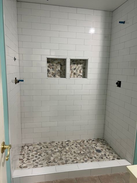 Shower Tile Ideas With Pebble Floor, White Subway Tile Shower With Stone Floor, 4x 12 Subway Tile Bathroom, Shower Tile With Pebble Floor, Walk In Shower With Pebble Floor, Shower With Pebble Floor River Rocks, Showers With Pebble Floors River Rocks, Natural Rock Shower Floor, White Subway Tile Shower With River Rock Floor