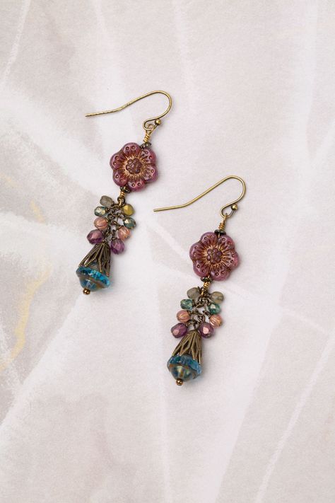 From the Mauve collection these earrings are longer in design and handcrafted with a fun Czech glass flower focal. Antique Brass (nickel and lead-safe) Czech Glass 2.5", with antique brass ear wires We hand select our natural materials, thus there may be slight variations in color and/or size that will not detract from the overall aesthetic Our unique handcrafted designer jewelry for women is made in America, each design created individually in our personal design studio in Floyd VA USA Handmade Bohemian Flower Earrings With Czech Glass, Beaded Flower Earrings In Czech Glass, Bohemian Flower Czech Glass Earrings, Flower-shaped Beaded Czech Glass Earrings, Purple Czech Glass Drop Earrings, Floyd Va, Czech Glass Jewelry, Flower Cluster, Designer Handmade Jewellery