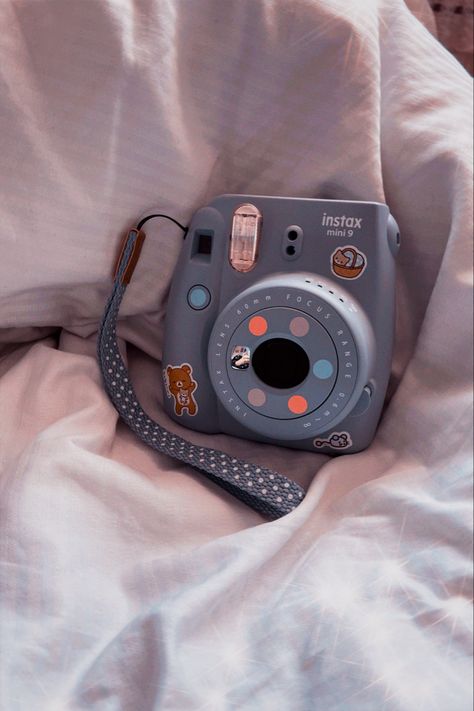 pastel purple instant/polaroid camera decorated with assorted stickers of rilakkuma and some cats, and also some pastel coloured dot stickers. the camera sits on a white/grey striped cloth background and the photo has a peach tint to it because of the filter i took it with Polaroid Instax Mini, Instax Mini 9, Polaroid Instax, Instax Mini Film, Instax Camera, Cute Camera, Polaroid Camera, Paper News, Instant Camera