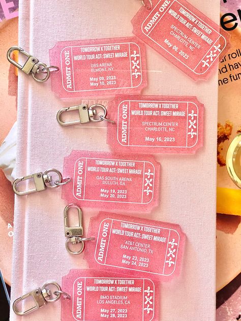 Get your hands on our limited edition Tomorrow Together concert tour keychain and show your love for one of your favs! Made with high-quality pink transparent glitter acrylic, this keychain features a stylish ticket design that matches their  concert theme colors. This keychain is the perfect accessory for any kpop fan, and it's a great way to commemorate their World Tour Act Sweet Mirage. It's also a great addition to any collection of kpop merchandise, and it's sure to be a conversation starter among your fellow Kpop enthusiasts. Order your concert tour keychain today while supplies last! Don't miss out on this opportunity to own a piece of history and show your support for the boys! Concert Merchandise Ideas, Kpop Event Ideas, Kpop Concert Ticket, Kpop Concert Freebies, Keychain Merchandise, Merchandise Ideas Products, Kpop Packaging, Concert Freebies, Concert Theme