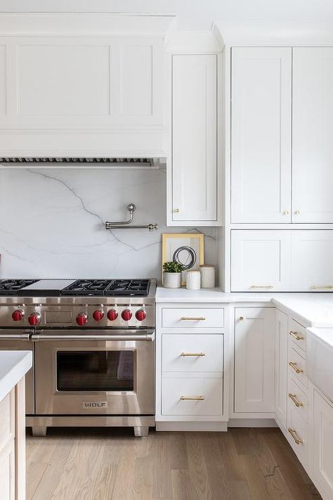 Wolf dual range with a white wooden range hood transforms a kitchens cooktop accented with a honed white marble slab backsplash. Wooden Range Hood, Kitchen Hood Design, Kitchen Cooktop, Kitchen Range Hood, Kitchen Hoods, Classic Kitchen, Transitional Kitchen, Kitchen Marble, White Kitchen Cabinets