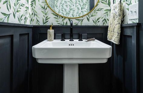 A white pedestal sink is contrasted with a matte black faucet and fixed in front of a black board and batten wall finished with green botanical wallpaper. Bathroom Design With Wallpaper, Powder Room Pedestal Sink, Dark Stained Wood Floors, Blue Powder Rooms, Black Powder Room, Midcentury Ranch, Staining Wood Floors, Batten Walls, Half Bath Decor