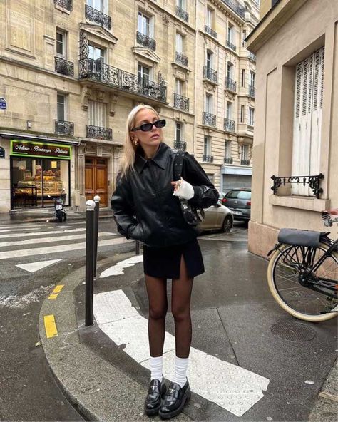 Girl wearing black leather bomber jacket, black mini skirt, black tights, white socks and black loafers. She is standing on a street corner 00s Mode, Biker Shorts Outfit, Autumn Fits, Paris Mode, Leather Jacket Outfits, Miniskirt Outfits, Paris Outfits, Looks Street Style, Blair Waldorf