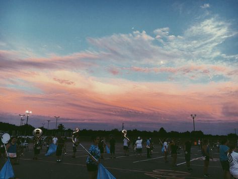 photography, marching band, sky, sunset, sousaphones, woodwinds, brass section, color guard, aesthetic