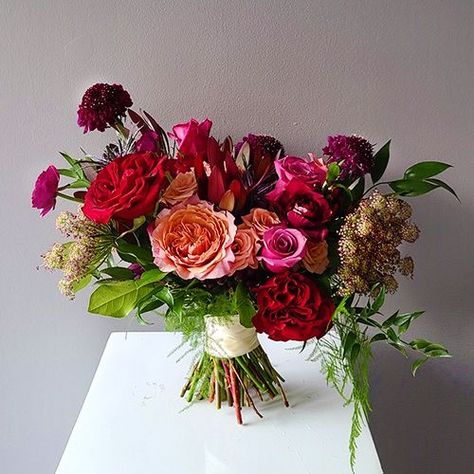 A gorgeous classically styled bouquet featuring a blend of roses, hydrangea, thistle, scabiosa, and other textures, hand-tied with a ribbon wrapped stem. Perfect for autumn destination weddings, courthouse surprises, and romantic elopements. Hot Pink Wedding Bouquet, Jewel Tone Wedding Flowers, Jeweled Bouquet, Pallet Wedding, Hot Pink Weddings, Red Bouquet Wedding, Pavilion Wedding, Jewel Tone Wedding, Wedding Bouquets Pink