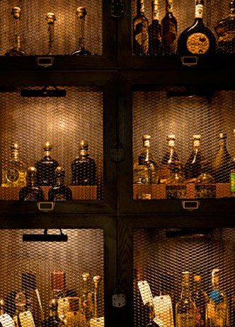 The wire cabinet doors offer great visual interest with a masculine touch. Avroko Bar, Wine Doors, Locker Inspiration, Bar Deco, Mesh Doors, Whiskey Room, Drink Bar, Whiskey Bar, Home Bar Designs