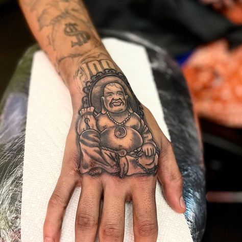 Uplifting Presence: Laughing Buddha Tattoo on Hand Buddhist Tattoo Sleeve, Laughing Buddha Tattoo, Buddha Tattoo Ideas, Buda Tattoo, Happiness Tattoo, Wrist Tattoo Ideas, Buddhist Tattoo, Tattoo On Hand, Buddha Tattoo Design