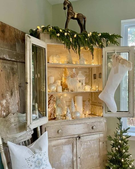 The thrill of decorating your home for Christmas can manifest in various ways, including focusing your decorating efforts to a specific area. A good example is using a distressed hutch to display items in the spirit of a winter wonderland. Keep the cabinet doors open and illuminate the decor with twinkle lights for a more eye-catching design...   Image: le.lis.home Christmas China Cabinet Decor, Christmas Hutch Decorating Ideas, Christmas Hutch Decor, Distressed Hutch, Christmas Hutch, French Country Christmas Decor, Console Table White, Decorating A Christmas Tree, Wonderland Decorations